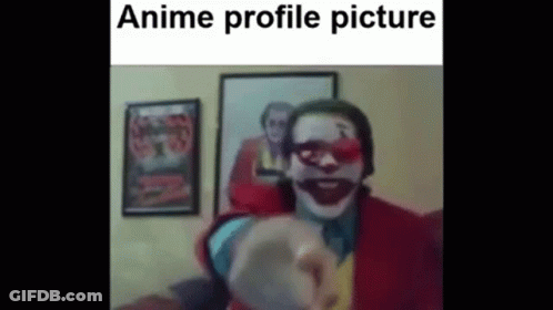 A Man In A Clown Costume Is Pointing At The Camera In Front Of A Picture Of The Joker . GIF