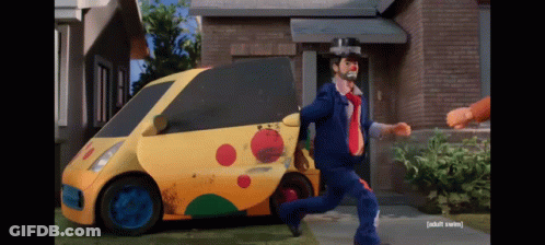 A Man In A Clown Costume Is Running Away From A Yellow Car That Says Taxi GIF