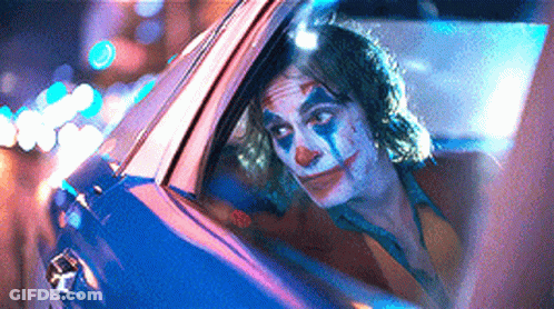 A Man In A Clown Costume Is Sitting In A Car . GIF
