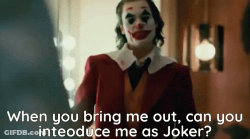 A Man In A Clown Costume Is Standing In A Room And Talking To Another Man . GIF