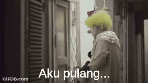 A Man In A Clown Costume Is Standing In Front Of A Door And Saying Aku Pulang . GIF