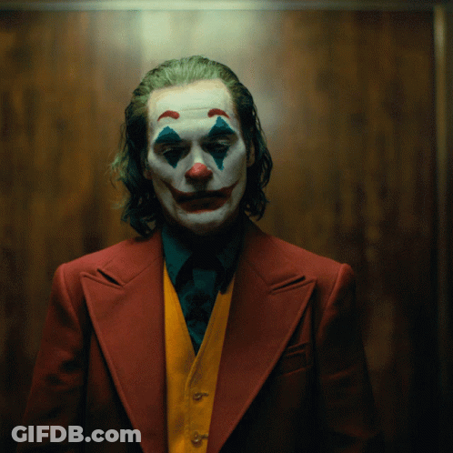 A Man In A Clown Costume Is Wearing A Red Suit And A Yellow Vest GIF