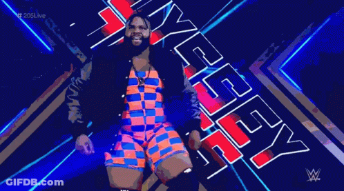 A Man In A Colorful Outfit Is Standing In Front Of A Sign That Says Wwe . GIF