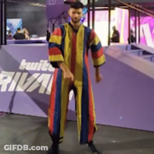A Man In A Colorful Robe Is Standing In Front Of A Purple Wall That Says Rival GIF