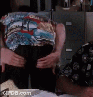 A Man In A Colorful Shirt Is Being Held By Another Man GIF