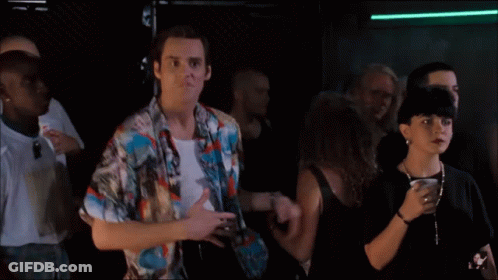 A Man In A Colorful Shirt Is Dancing In A Crowd Of People GIF