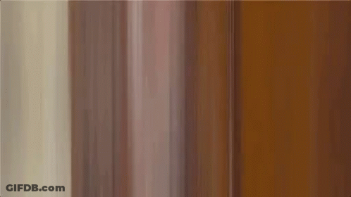 A Man In A Colorful Shirt Is Making A Funny Face . GIF