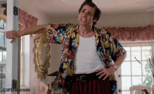 A Man In A Colorful Shirt Is Standing In Front Of A Door GIF
