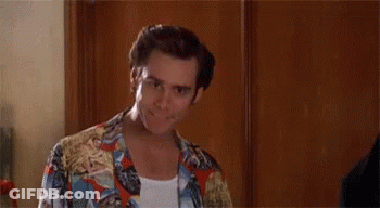 A Man In A Colorful Shirt Is Standing In Front Of A Wooden Door And Says `` Alright Then ! '' GIF
