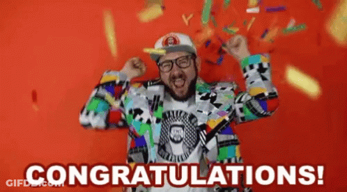 A Man In A Colorful Suit Is Celebrating With Confetti Falling Around Him And The Words Congratulations ! GIF