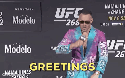 A Man In A Colorful Suit Is Standing In Front Of A Ufc 268 Sign GIF