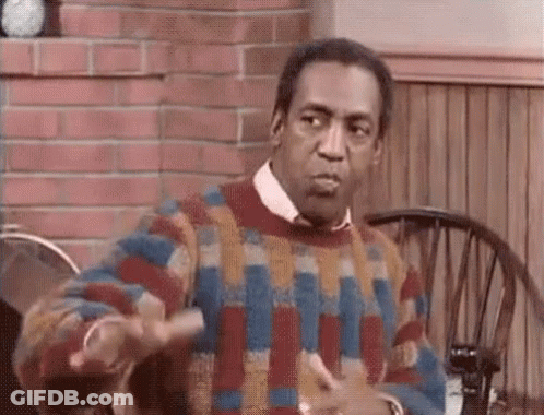 A Man In A Colorful Sweater Is Sitting At A Table With A Wheelchair . GIF