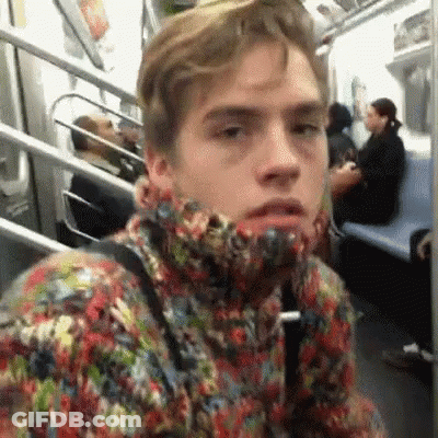 A Man In A Colorful Sweater Is Sitting On A Subway Train . GIF