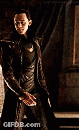 A Man In A Costume Is Holding A Knife In His Hand . GIF