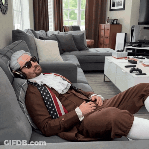 A Man In A Costume Is Laying On A Couch GIF