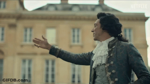 A Man In A Costume Is Standing In Front Of A Building With Netflix Written On The Bottom Of The Screen GIF