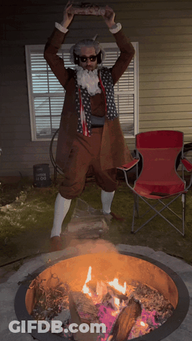 A Man In A Costume Is Standing In Front Of A Fire Pit GIF