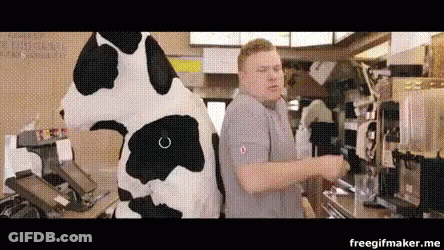 A Man In A Cow Costume Is Standing Next To A Cow Mascot In A Restaurant . GIF