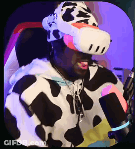 A Man In A Cow Costume Is Wearing A Virtual Reality Headset In Front Of A Microphone GIF