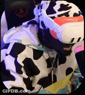 A Man In A Cow Print Hoodie Is Wearing A Virtual Reality Headset . GIF