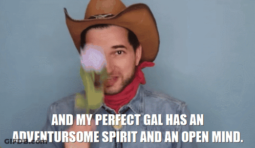 A Man In A Cowboy Hat And Scarf Says " And My Perfect Gal Has An Adventursome Spirit And An Open Mind " GIF