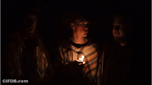 A Man In A Cowboy Hat Holds A Candle In His Hand GIF