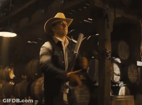 A Man In A Cowboy Hat Holds A Gun GIF