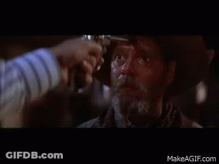 A Man In A Cowboy Hat Is Being Shot By Another Man With A Gun GIF