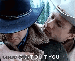 A Man In A Cowboy Hat Is Hugging Another Man In A Fur Coat . GIF