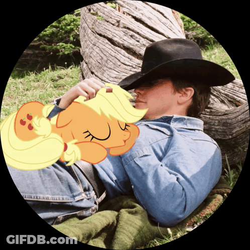 A Man In A Cowboy Hat Is Laying In The Grass With A Cartoon Pony Sleeping On His Chest GIF