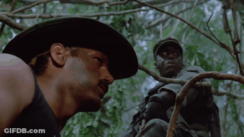 A Man In A Cowboy Hat Is Looking At Another Man GIF