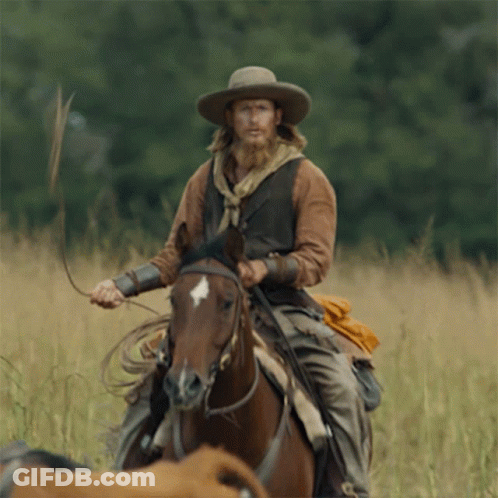 A Man In A Cowboy Hat Is Riding A Brown Horse GIF