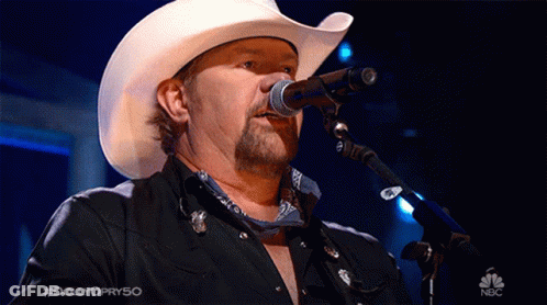 A Man In A Cowboy Hat Is Singing Into A Microphone On Nbc GIF