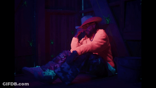 A Man In A Cowboy Hat Is Sitting On The Ground GIF