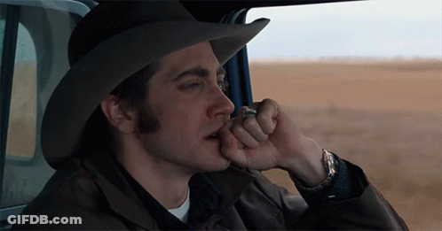 A Man In A Cowboy Hat Is Smoking A Cigarette In A Car GIF