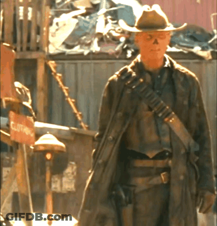 A Man In A Cowboy Hat Is Standing In Front Of A Clothing Store GIF