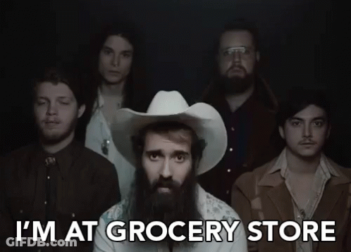 A Man In A Cowboy Hat Is Standing In Front Of A Group Of Men And Says I 'M At Grocery Store GIF