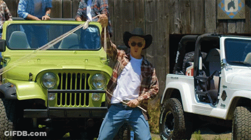 A Man In A Cowboy Hat Is Standing In Front Of A Jeep GIF