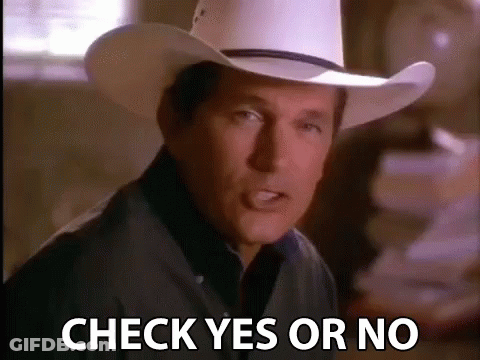 A Man In A Cowboy Hat Is Standing In Front Of A Pile Of Papers And Says Check Yes Or No . GIF