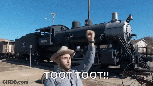 A Man In A Cowboy Hat Is Standing In Front Of A Train That Says Fresco On It GIF
