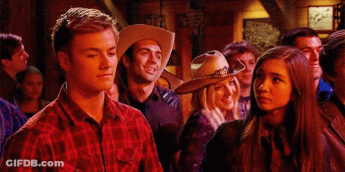 A Man In A Cowboy Hat Is Standing Next To A Woman GIF