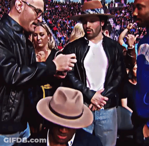 A Man In A Cowboy Hat Is Talking To Another Man GIF