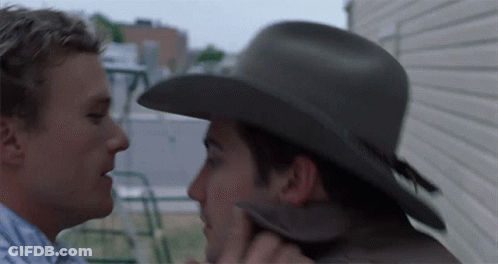 A Man In A Cowboy Hat Kisses Another Man GIF
