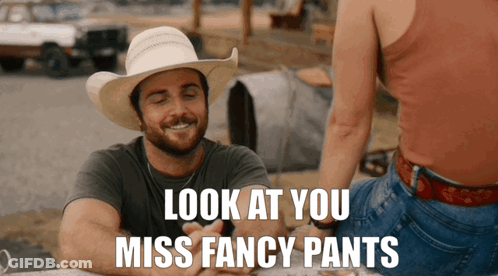 A Man In A Cowboy Hat Says Look At You Miss Fancy Pants While Sitting Next To A Woman GIF
