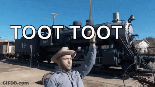 A Man In A Cowboy Hat Stands In Front Of A Train That Says Toot Toot On It GIF
