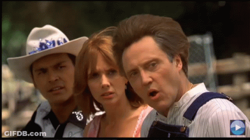 A Man In A Cowboy Hat Stands Next To A Woman And A Man Wearing Overalls GIF