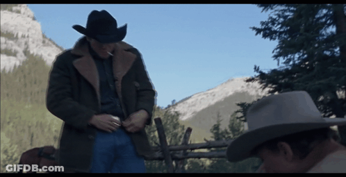 A Man In A Cowboy Hat Stands Next To Another Man GIF
