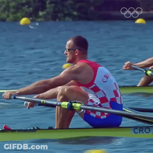 A Man In A Croatia Uniform Is Rowing A Boat In The Water GIF