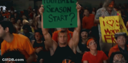 A Man In A Crowd Holds Up A Sign That Says Season Start GIF