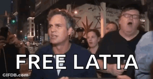 A Man In A Crowd Says Free Latta In Front Of A Police Officer . GIF